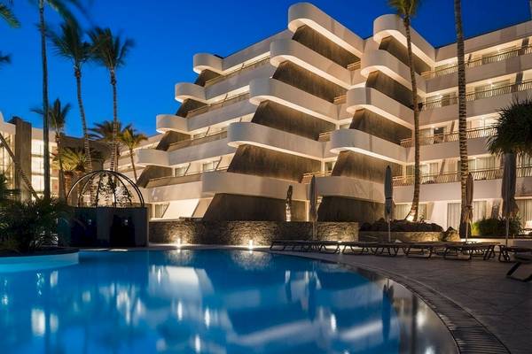 Plus Fariones Suite Hotel Pool bei Nacht mit beleuchtetem Gebäude und Sonnenliegen