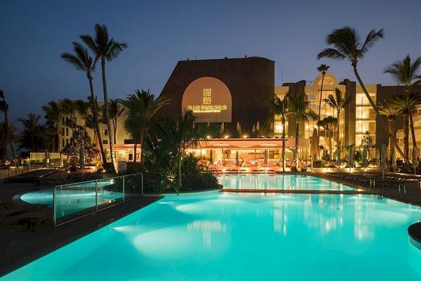 Der Pool des Plus Fariones Suite Hotels bei Nacht mit Palmen und Beleuchtung.