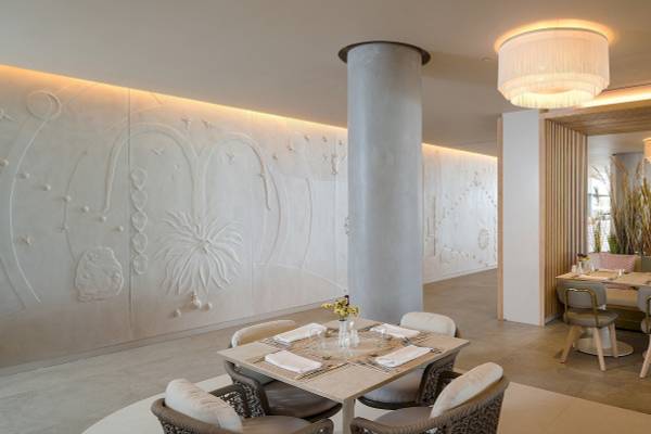 Plus Fariones Suite Hotel Innenraum mit weißen Wänden, Tisch und Stühlen.