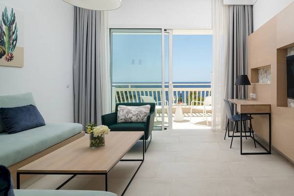 Plus Fariones Suite Hotel Innenraum Wohnzimmer mit Sofa, Tisch, Fenstern und Meerblick.