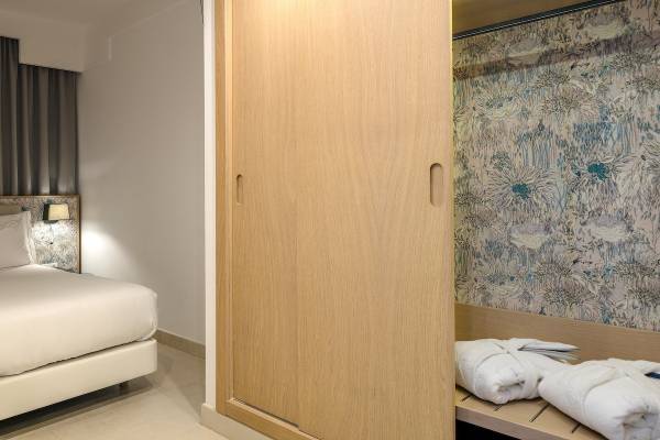 Ein Hotelzimmer mit einem Bett, einem Kleiderschrank und Handtüchern.
