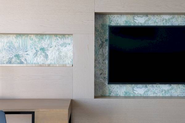 Inneneinrichtung des Plus Fariones Suite Hotel mit Fernseher und blauem Blumenmuster.