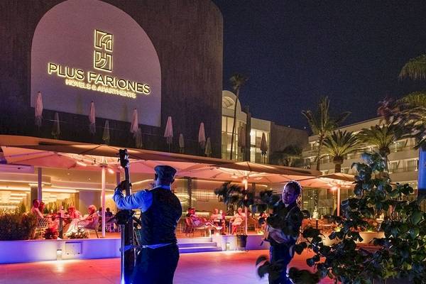 Außenbereich des Plus Fariones Suite Hotels bei Nacht mit Beleuchtung und Gästen.