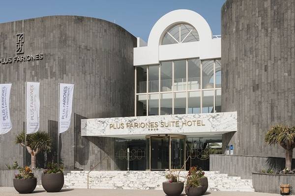 Vorderansicht des Plus Fariones Suite Hotel mit einfahrt und flaggen