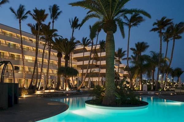 Außenbereich des Plus Fariones Suite Hotel mit Swimmingpool und Palmen