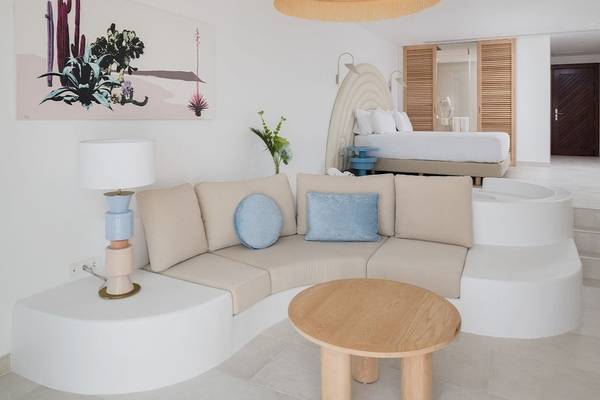 Plus Fariones Suite Hotel Innenraum mit Couch, Tisch und Bett.