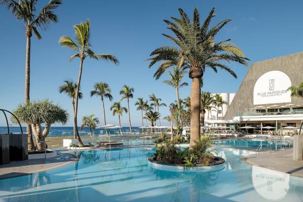 Außenpool des Plus Fariones Suite Hotels mit Loungebereich und Palmen