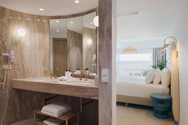 Badezimmer des Plus Fariones Suite Hotel mit Blick auf das Meer und ein Bett