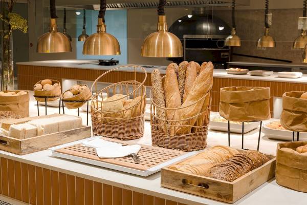 Frühstücksbuffet im Plus Fariones Suite Hotel mit verschiedenen Brotsorten, Brötchen und anderen Gebäck.
