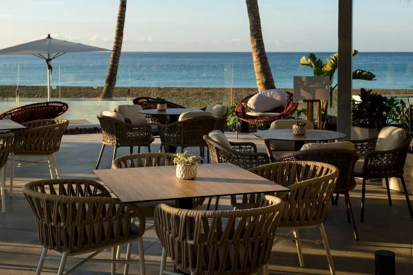 Außenterrasse des Plus Fariones Suite Hotels mit Blick auf das Meer und Palmen