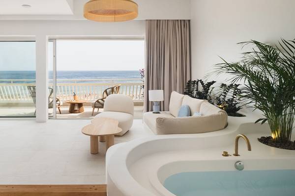 Wohnbereich des Plus Fariones Suite Hotel mit Blick auf den Balkon und das Meer.