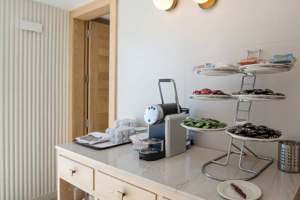 Kaffeemaschine und Gebäcke auf einem Tisch im Plus Fariones Suite Hotel.