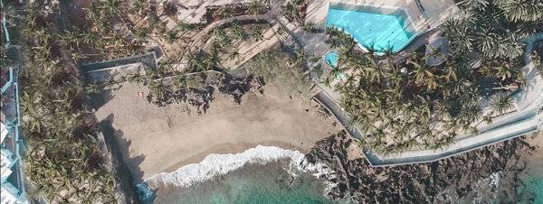 Luftaufnahme des Fariones Hotels mit Swimmingpool und Palmen am Strand