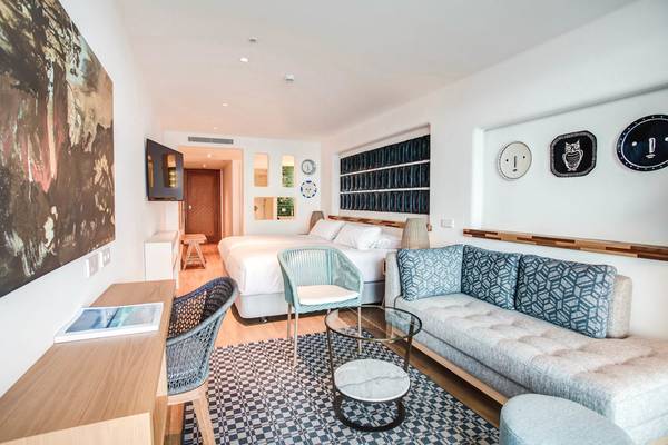 Innenansicht eines Zimmers im Fariones Hotel mit Bett, Sofa, Schreibtisch und Dekor.