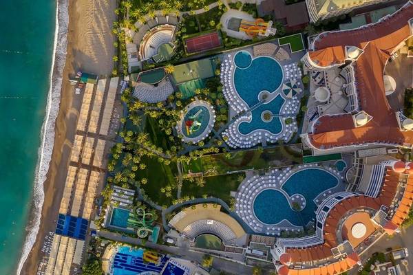 Luftaufnahme des Kirman Leodikya Resorts mit Swimmingpools, Tennisplätzen und einem Amphitheater am Strand