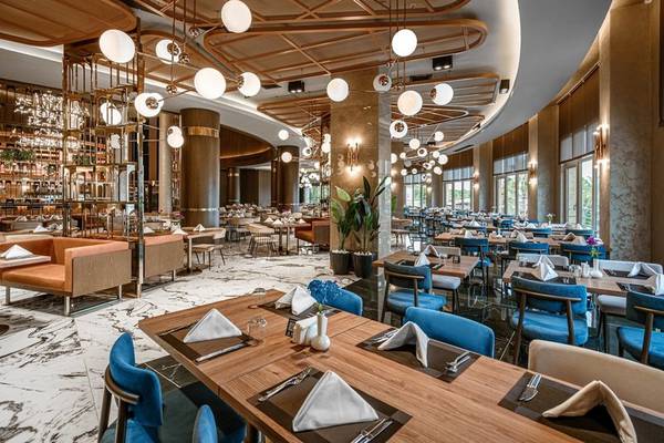 Innenbereich des Restaurants im Kirman Leodikya Resort mit eleganten Tischdecken und modernen Möbeln.