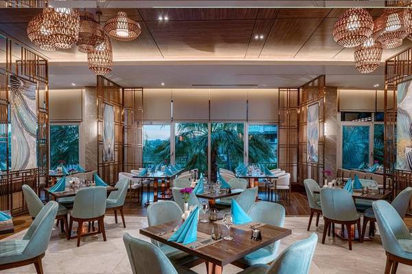 Innenansicht des Restaurants im Kirman Leodikya Resort mit blauen Stühlen und Tischen.