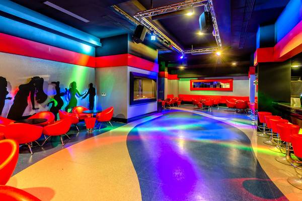 Disco-Bereich des Kirman Leodikya Resorts mit roten Stühlen und farbigen Lichtern.