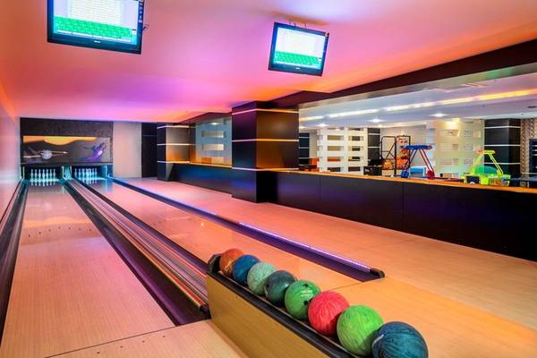 Bowlingbahn im Kirman Leodikya Resort Hotel mit bunten Lichtern und Bowlingkugeln.