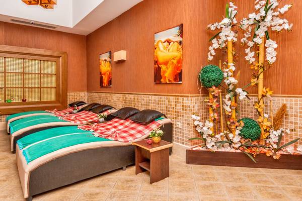 Spa-Behandlungsraum im Kirman Leodikya Resort mit Liegen und Pflanzendekoration.