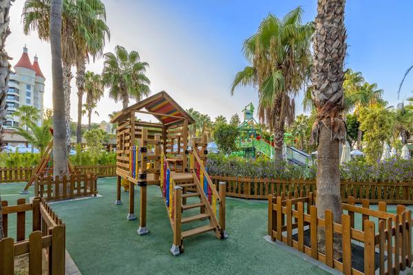 Kinderspielplatz im Kirman Leodikya Resort mit Holzspielhaus und Rutsche