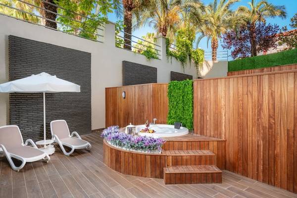Jacuzzi auf der Terrasse des Kirman Leodikya Resorts mit zwei Liegen und einem Schirm