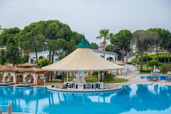 Pool-Loungebereich des Ducale Lara Hotels mit Blick auf den Pool und das umliegende Gelände.