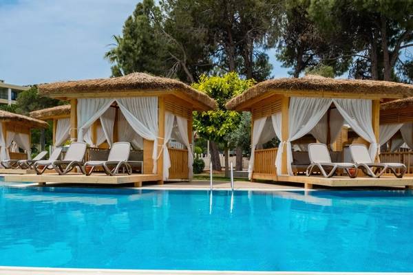 Außenbereich des Ducale Lara Hotels mit Pool, Sonnenliegen und Pavillons