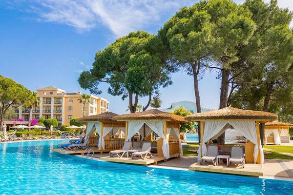 Pool-Loungebereich im Ducale Lara Hotel mit Sonnenschirmen und Liegestühlen.
