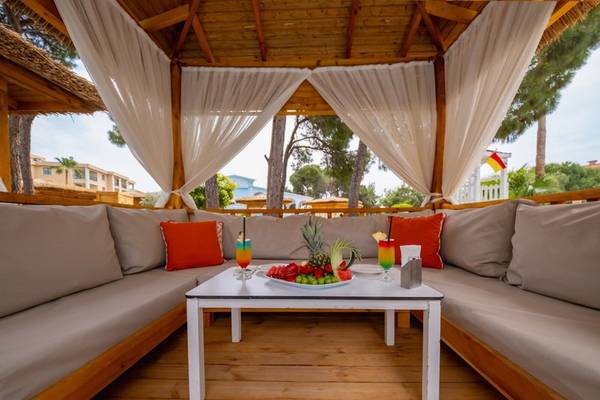 Gazebo mit Sofas und Tisch im Ducale Lara Hotel, gefüllt mit Früchten und Getränken.