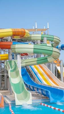 Wasserrutschen im Ducale Lara Hotel, bunte Rutschen über einem Pool.
