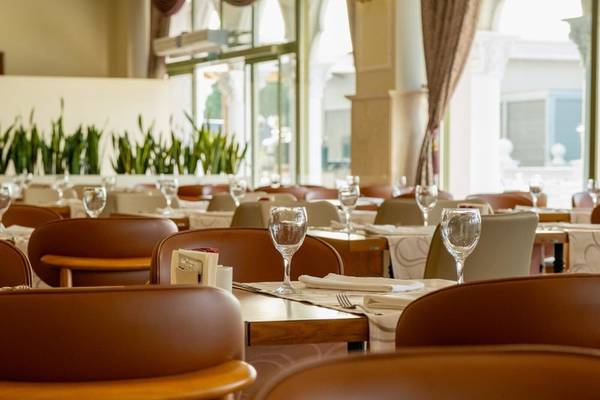 Innenansicht des Restaurants des Ducale Lara Hotels mit gedeckten Tischen und Stühlen.