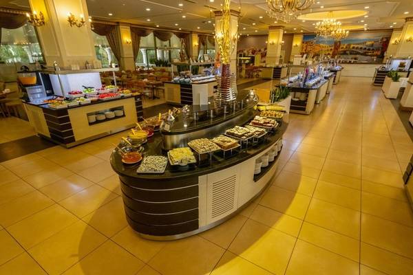 Buffetbereich im Ducale Lara Hotel mit vielen Speisen und gedeckten Tischen.