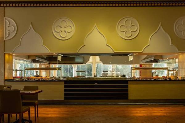 Innenansicht des Restaurants im Ducale Lara Hotel mit Tisch, Stühlen und Küchenbereich.