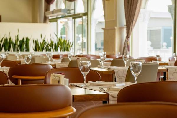 Innenbereich des Restaurants im Hotel Ducale Lara mit gedeckten Tischen und Stühlen.