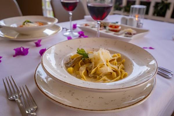 Tisch mit Essen im Ducale Lara Hotel mit einer Tasse Wein und Tellern mit Gerichten.
