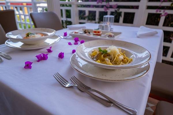 Tisch mit Essen im Hotel Ducale Lara, Teller und Servietten auf dem Tisch.