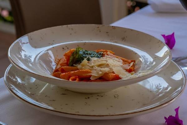 Ein Teller mit Penne Pasta und Blattspinat auf einem Tisch im Hotel Ducale Lara.
