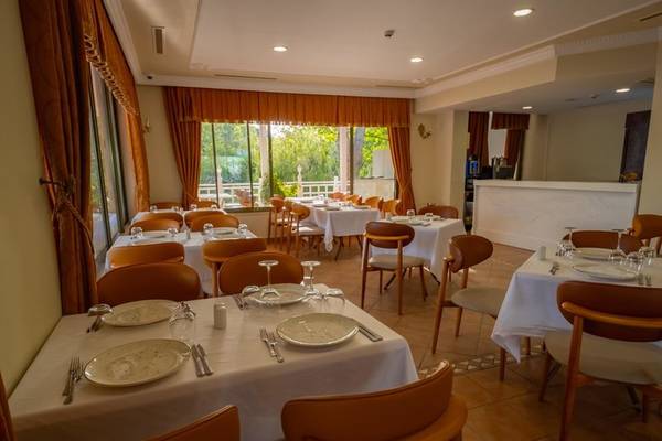 Innenansicht des Restaurants im Ducale Lara Hotel mit gedeckten Tischen und Stühlen.