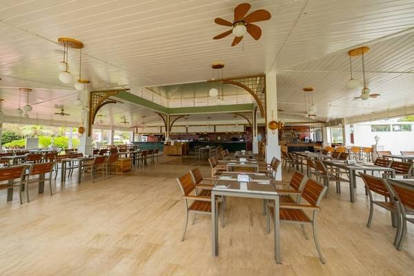 Innenbereich des Ducale Lara Hotels mit Holzböden und weißen Decken mit Ventilatoren.
