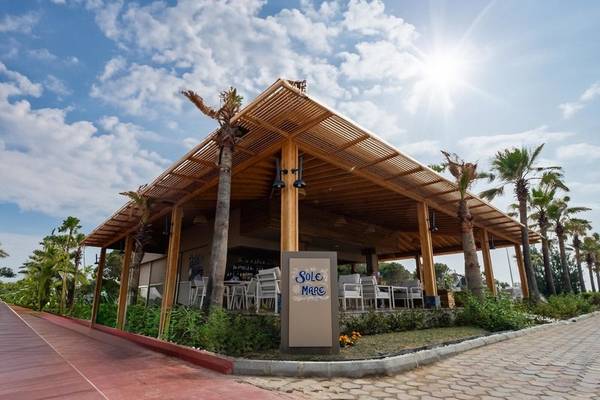 Außenterrasse des Ducale Lara Hotels mit Sonnenschirmen und Tischen im Freien.