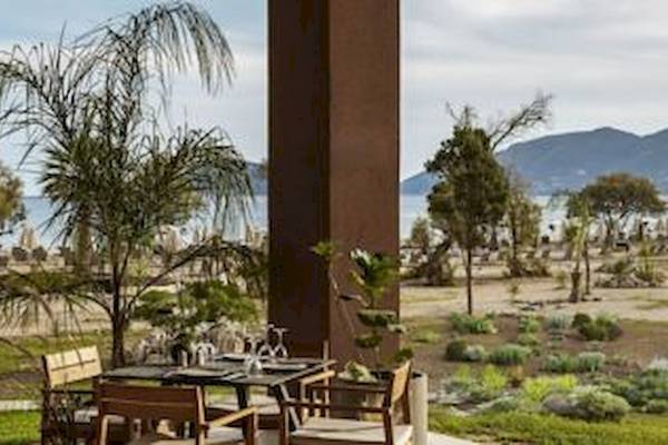 Außenbereich des Domes Aulus Zante Hotels mit Tisch und Blick auf das Meer.