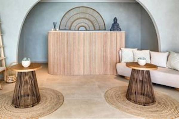 Eingangsbereich des Domes Aulus Zante Hotels mit Couch, Beistelltischen und einer Holzwand.