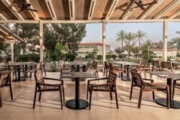 Terrasse des Domes Aulus Zante Hotels mit Tischen und Stühlen unter einer Überdachung.