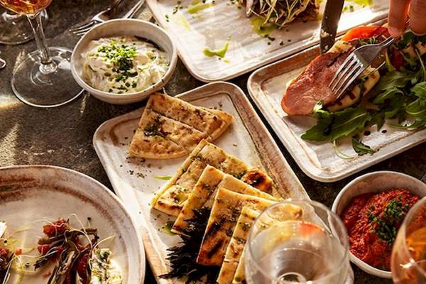Verschiedene Speisen auf dem Tisch im Domes Aulus Zante, einschließlich Fleisch, Gemüse und Dips.
