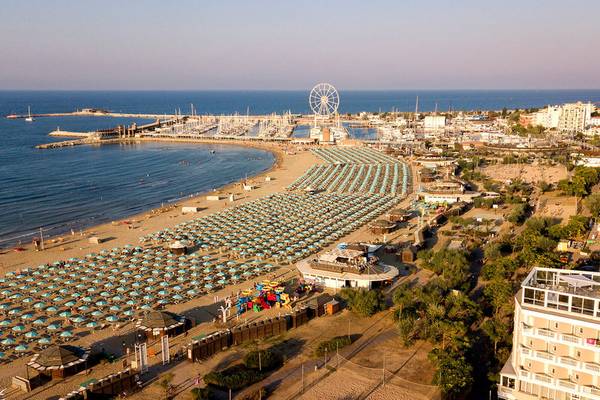 Luftaufnahme des Baia Imperiale Hotels am Strand mit vielen Sonnenschirmen und einem Riesenrad.