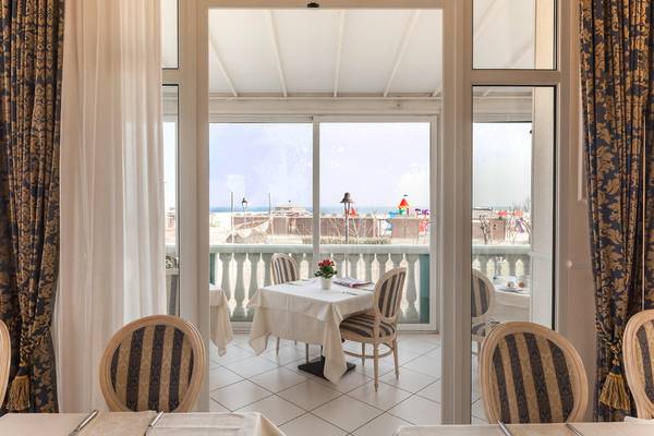 Innenansicht des Restaurants im Baia Imperiale Hotel mit Blick auf eine Terrasse und das Meer.