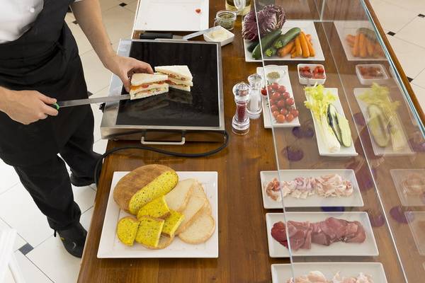 Ein Kellner im Baia Imperiale Hotel schneidet ein Sandwich auf einem Buffettisch.
