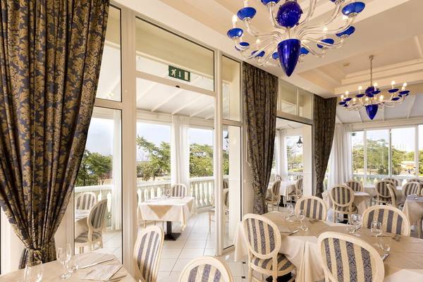 Innenansicht des Restaurants im Baia Imperiale Hotel mit blauen Kronleuchtern und Tischdekoration.