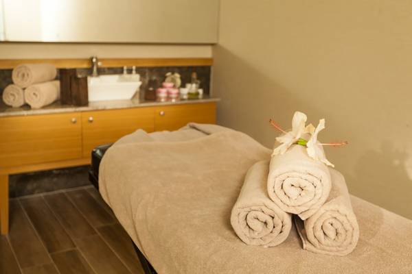 Massageliege mit Handtüchern und Blumen im Belek Beach Resort Hotel.